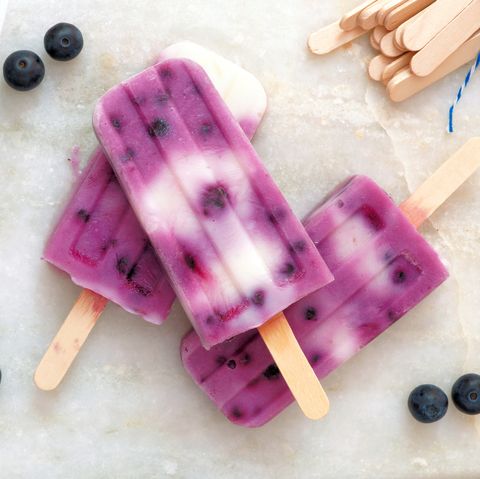 Blueberry vanilla popsicles on a white marble background