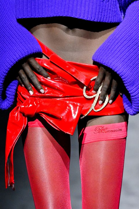 a black model wears a red and purple ensemble