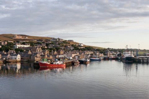 Boten afgemeerd in haven tegen lucht in Orkney