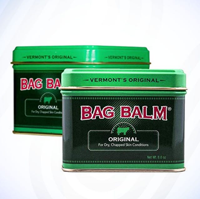 Two tins of Bag Balm in green against a blue curved background