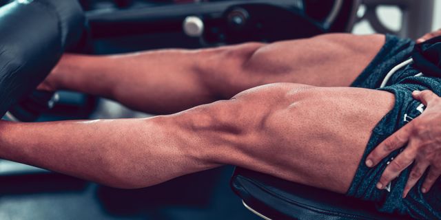 bodybuilder working leg muscles in gym
