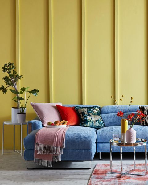 bright living room with yellow paneled wall and blue sofa