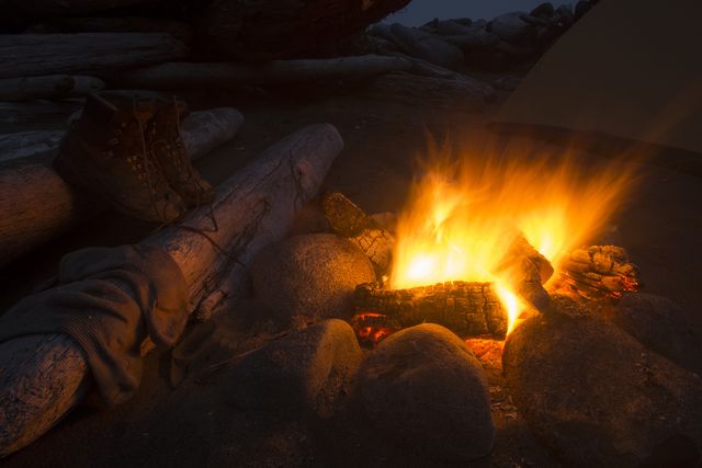 boots drying near burning campfire at night