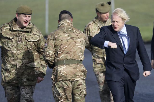 embargoed until 1400 gmt  british prime minister boris johnson greets troops, with brigadier chris davies, left, commander 38 irish brigade during a visit to joint helicopter command flying station aldergrove, northern ireland, friday, march, 12, 2021  ap photopeter morrison