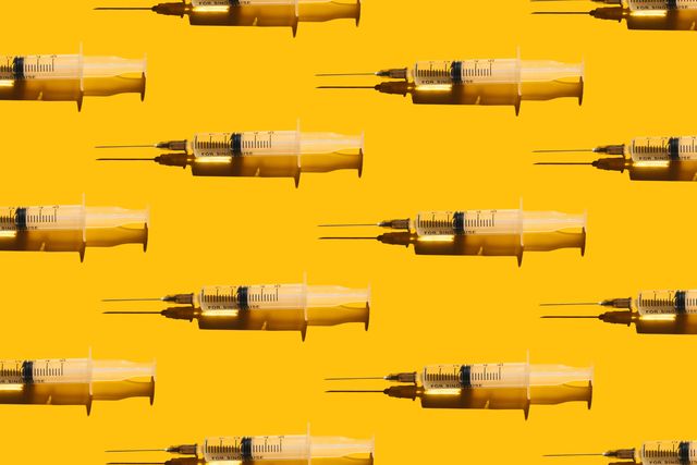 pattern of syringes with a vaccine on yellow background concept of medical treatment or vaccination