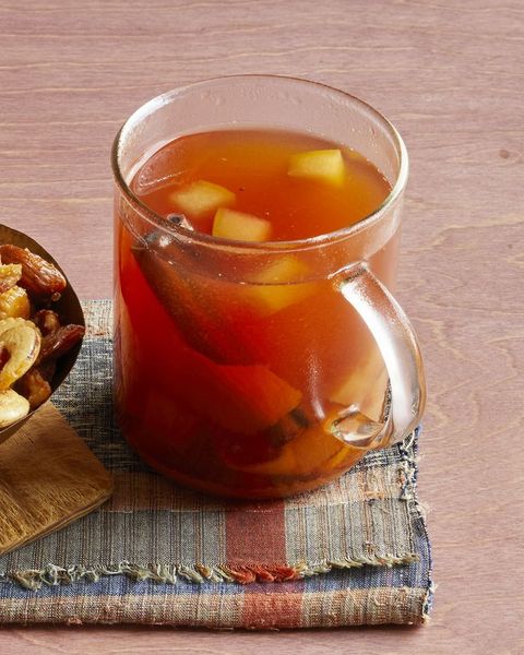 mulled cider with bourbon on plaid linen with nuts