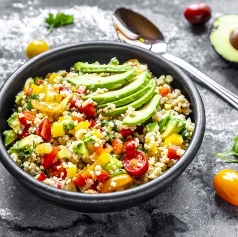 bowl of bulgur salad with bell pepper, tomatoes, avocado, spring onion and parsley
