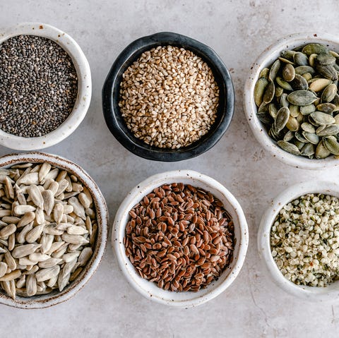 bowls of chia, sesame, pumpkin, sunflower, flax sesame and hemp seeds on a table