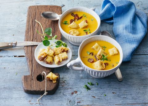 bowls of pumpkin soup with cheese croutons and bacon