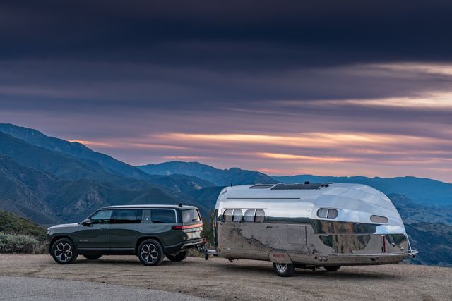 bowlus trailer towed by rivian r1s at sunset