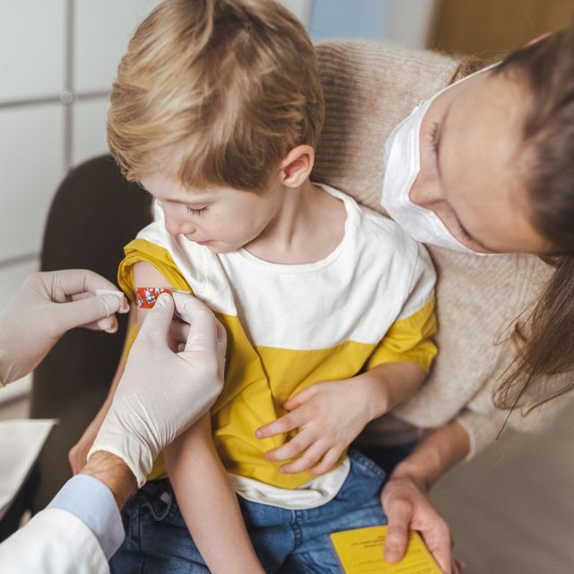 boy getting bandage by doctor after vaccination at center