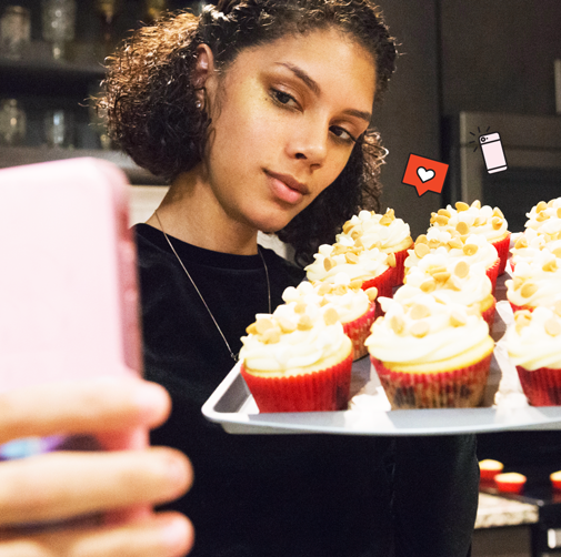 woman taking a selfie with vanilla cupcakes