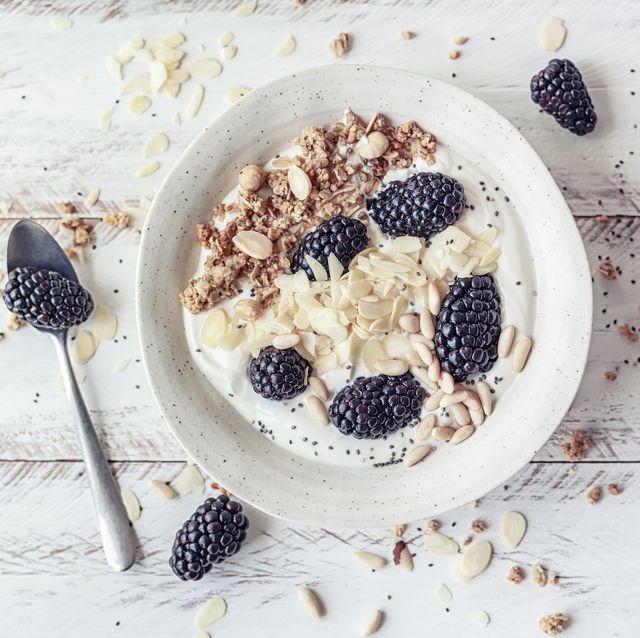 Breakfast bowl with homemade granola, dried fruits, blackberries and almond yogurt