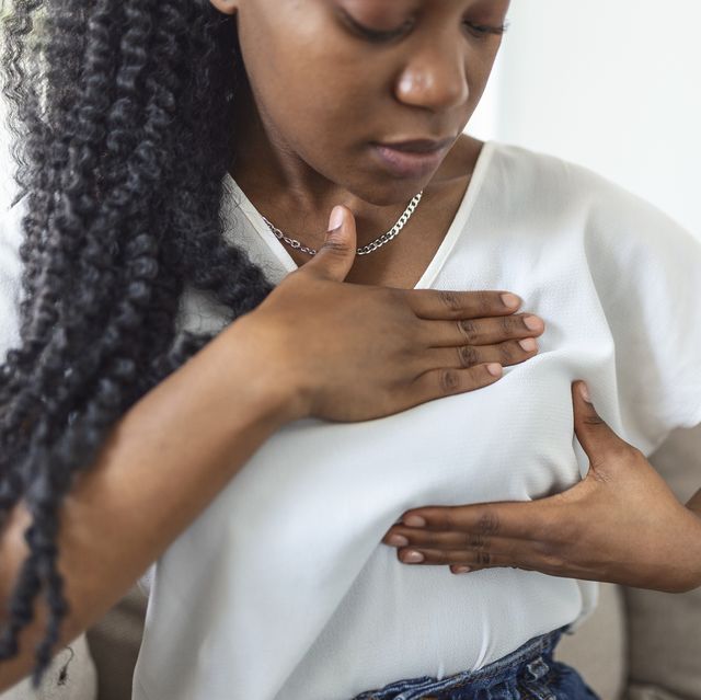 woman palpating her breast by herself that she concern about breast cancer