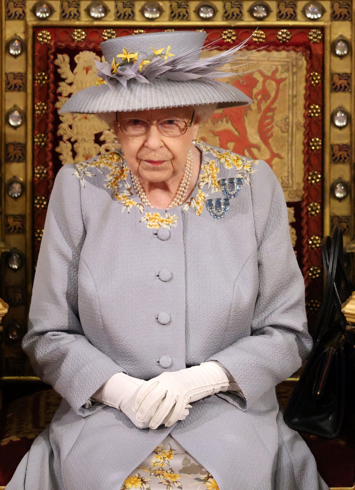 Queen Elizabeth Wears Lilac Day Dress and Hat at a Scaled-Back State