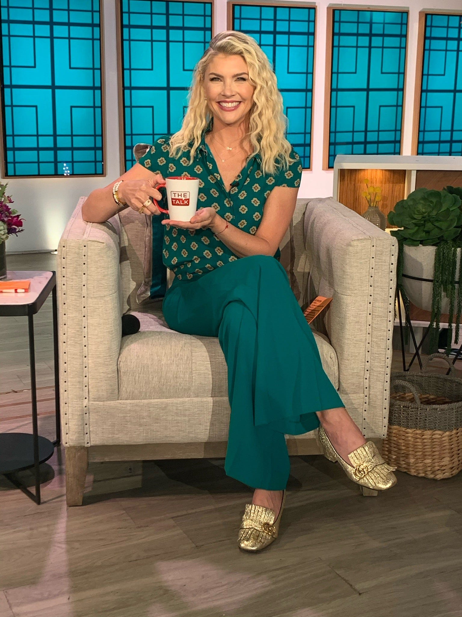 amanda kloots sul set di talk show, il talk sorridente e con in mano una tazza di caffè