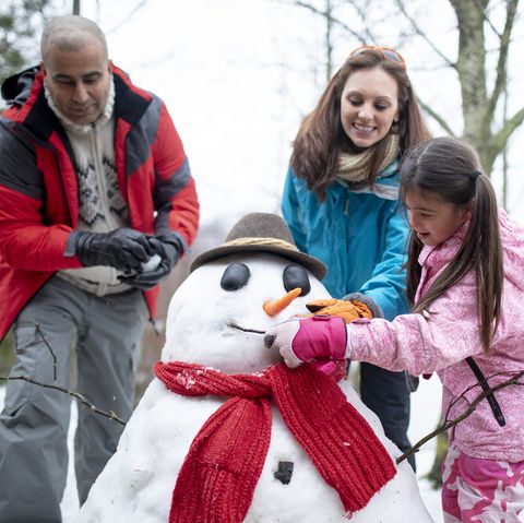 building a snowman with her family