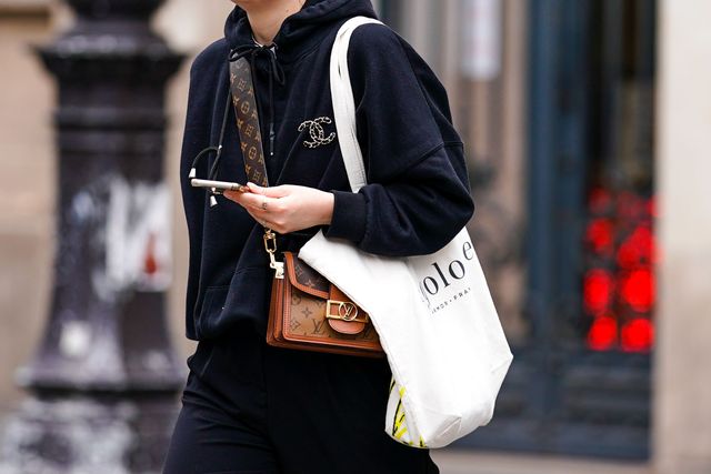 paris, france   july 04 a passerby wears a black hoodie sweater, a chanel brooch, a brown leather louis vuitton monogram bag, a white tote bag, on july 04, 2020 in paris, france photo by edward berthelotgetty images