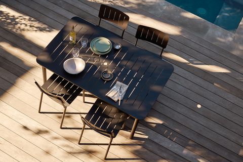 black burrow patio table and chairs on a pool deck