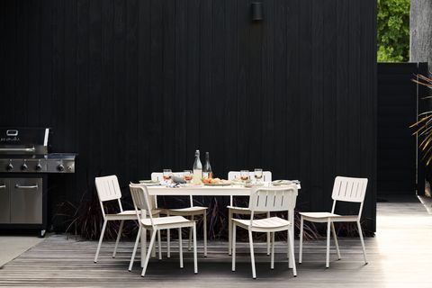 a white table and chairs on a deck next to a grill