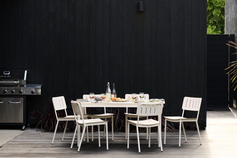 a white table and chairs on a deck next to a grill