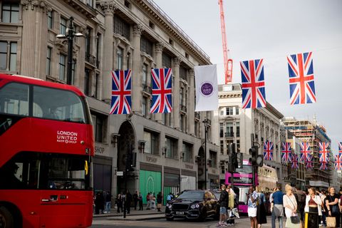 a bus drives under the union jack flags on oxford circus