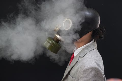 Business Concepts. Businessman wearing a gas mask on a black background. Businessmen wear gas . Businessmen wear gas masks to prevent pollution and toxins.,Pollution Prevention,Environment.