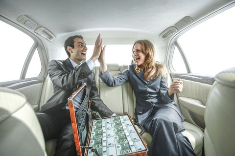 Business people high fiving in backseat of car