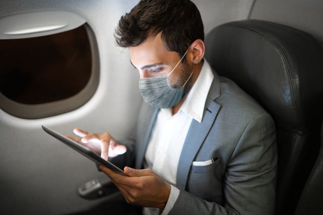businessman flying using digital tablet with protective mask