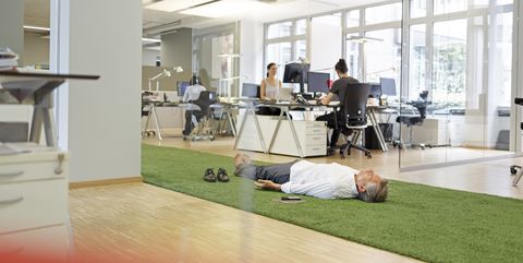 Businessman lying on carpet in office