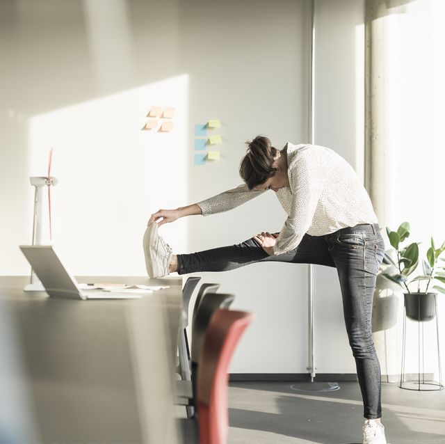 Businesswoman stretching in office