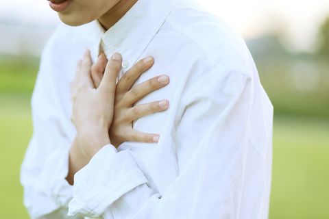 businesswoman suffering from chest pain outdoors