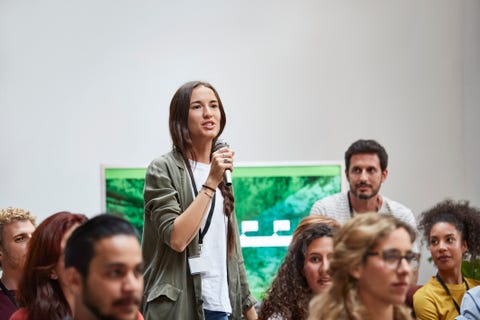 Businesswoman talking into microphone in seminar