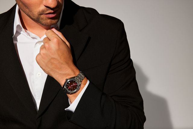 a man in a suit with his hand on his chin wearing bulova watch
