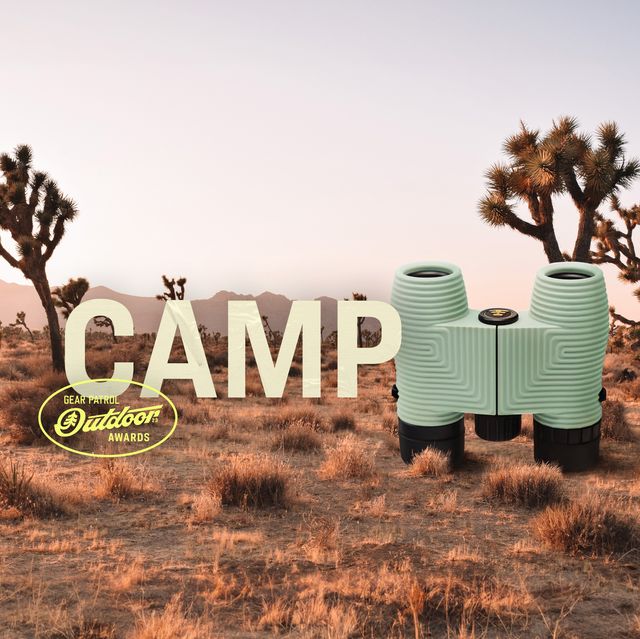 binoculars in a desert landscape with a camp headline and outdoor badge icon