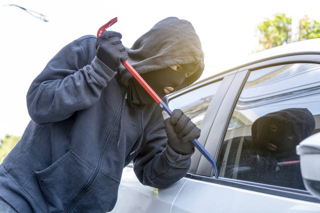 car theft thief trying to break into the vehicle