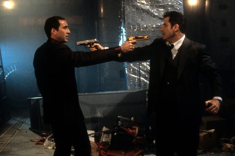 Nicolas Cage And John Travolta In 'Face/Off' nicolas cage and john travolta aiming guns at each other in a scene from the film faceoff, 1997 photo by touchstonegetty images