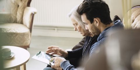 caretaker and senior woman using digital tablet at nursing home