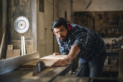 carpenter cutting wooden plank