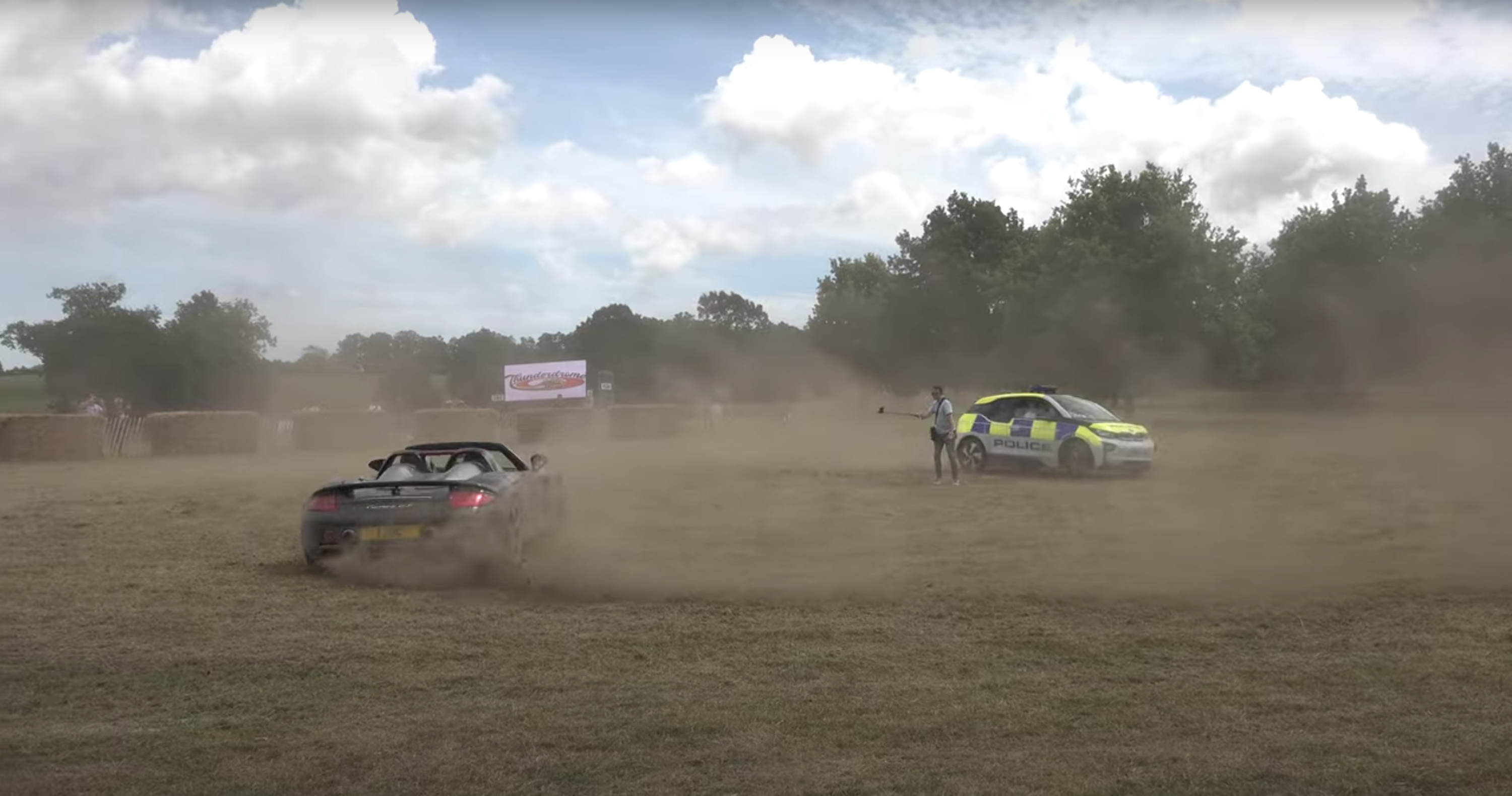 Watch This Carrera GT Drift Around A BMW i3 Cop Car on Grass