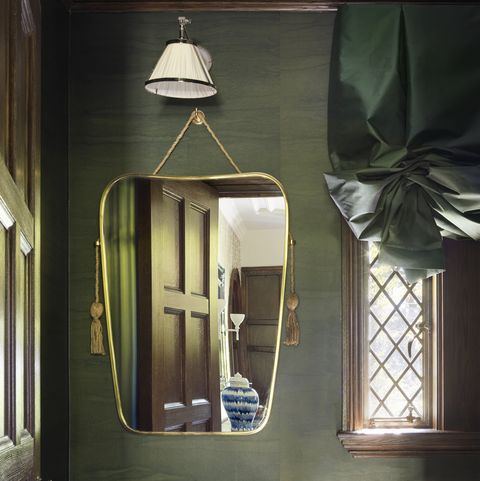 a polished nickel and stone washstand with tasseled, art deco–inspired mirror