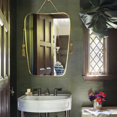 a polished nickel and stone washstand with tasseled, art deco–inspired mirror