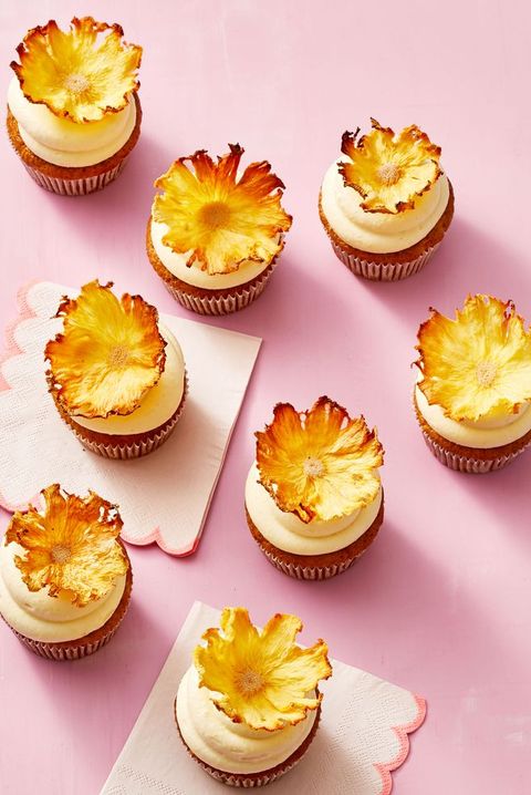 carrot pineapple cupcakes against a pink background