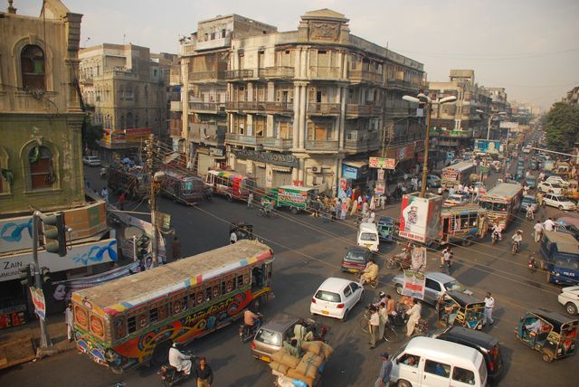 cars moving on road with buildings in karachi, pakistan