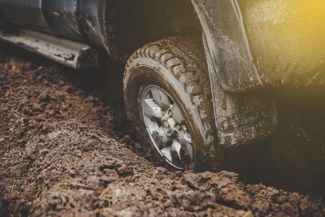 close up car tires are dirty on the mud during the rainy season outdoor adventure and travel