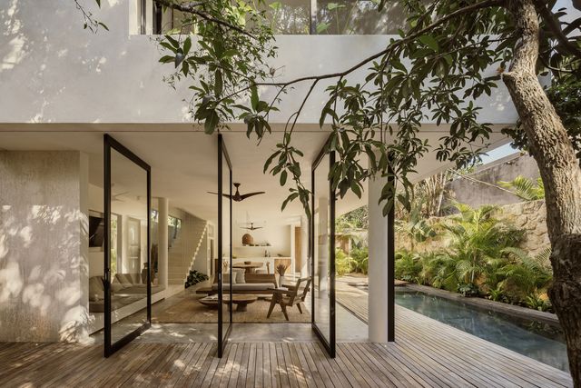 una casa de estilo natural abierta al jardín y la piscina
