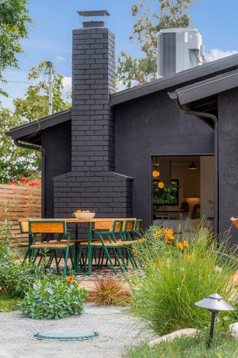 fachada negra y comedor en el jardín