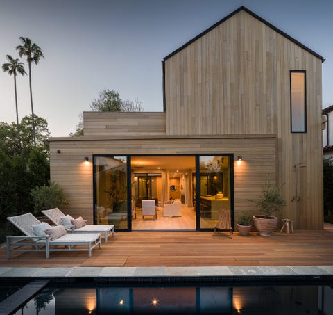 Una casa de madera de diseño moderno con piscina y porche