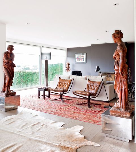 An open space home decorated in industrial style, antique northern furniture and African art