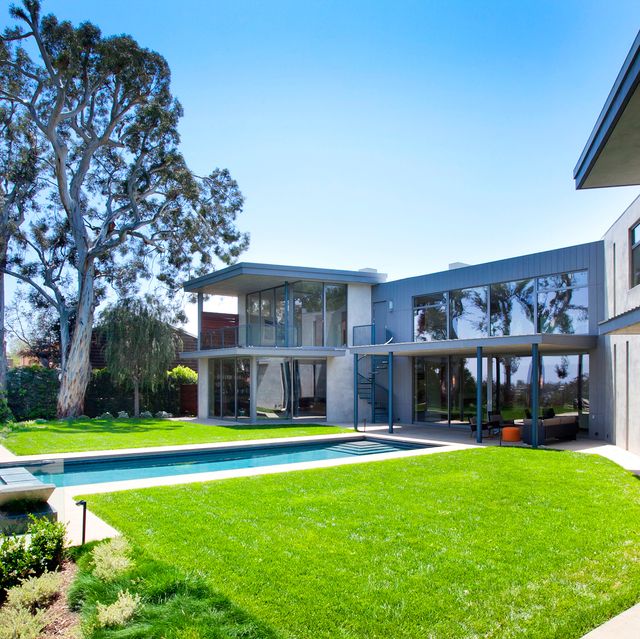 Una casa de estilo moderno con un espectacular jardín con piscina